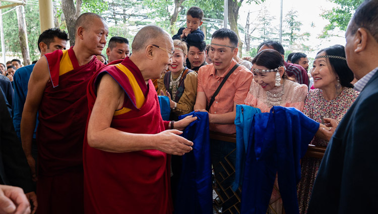 Seine Heiligkeit der Dalai Lama grüsst Teilnehmende und Zuschauer des Dialogs zwischen russischen Wissenschaftlern und buddhistischen Gelehrten auf dem Hof des tibetischen Haupttempels in Dharamsala, HP, Indien am 3. Mai 2018. Foto: Tenzin Choejor