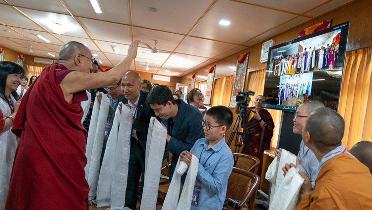 Seine Heiligkeit der Dalai Lama winkt den Teilnehmenden des Dialogs in Vietnam über Videokonferenzschaltung aus Residenz, in Dharamsala, HP, Indien am 21. Mai 2018. Foto: Tenzin Choejor