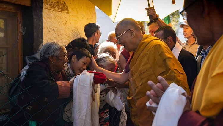 Seine Heiligkeit der Dalai Lama segnet wartende Menschen auf seinem Weg von der Residenz zum Shewatsel Vorlesungsgelände in Leh, Ladakh, J&K, Indien am 31. Juli 2018. Foto: Tenzin Choejor