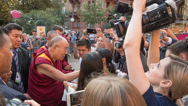 Seine Heiligkeit der Dalai Lama grüsst das wartende Publikum ausserhalb der Stadthalle in Heidelberg, Deutschland am 20. September 2018. Foto: Manuel Bauer
