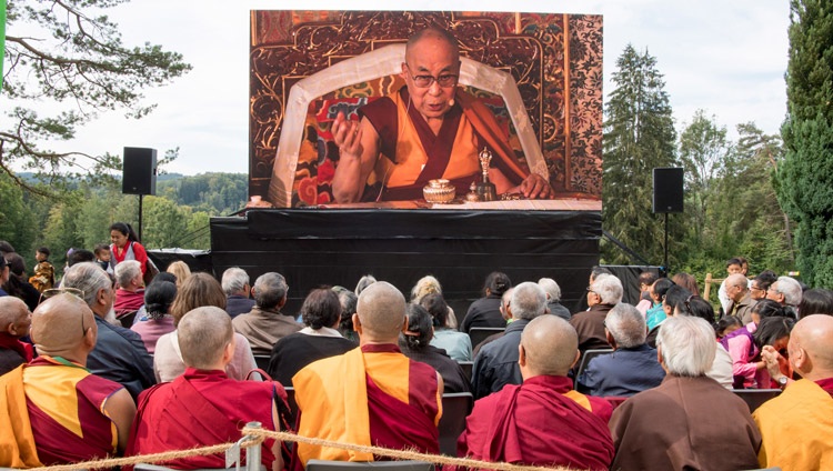 Das Publikum verfolgt die Rede Seiner Heiligkeit des Dalai Lama auf einem Bildschirm im Aussenhof des Tibet-Instituts in Rikon, Schweiz am 21. September 2018. Foto: Manuel Bauer