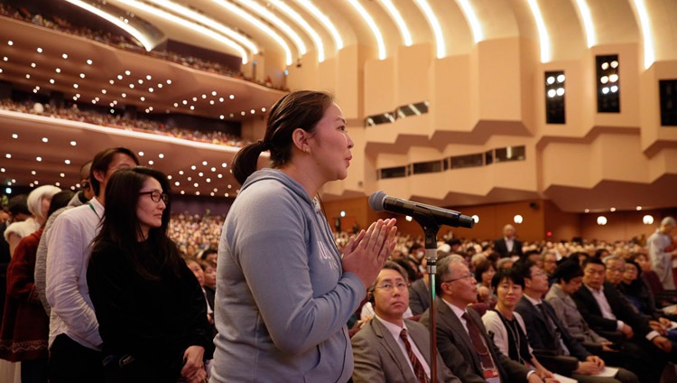 Ein Teilnehmende aus dem Publikum stellt Seiner Heiligkeit dem Dalai Lama eine Frage während des Wissenschaftsdialog in Yokohama, Japan am 16. November 2018. Foto: Tenzin Jigme