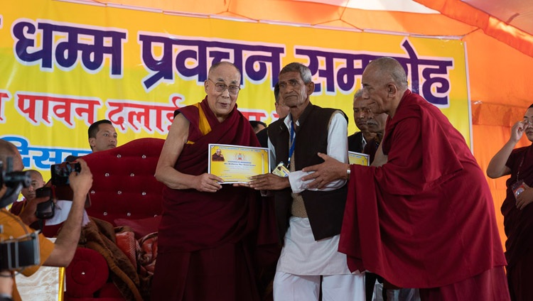 Seine Heiligkeit der Dalai Lama überreicht Dankeszertifikate an die Organisatoren der Unterweisungen am letzten Tag in Sankisa, UP, Indien am 5. Dezember 2018. Foto: Lobsang Tsering