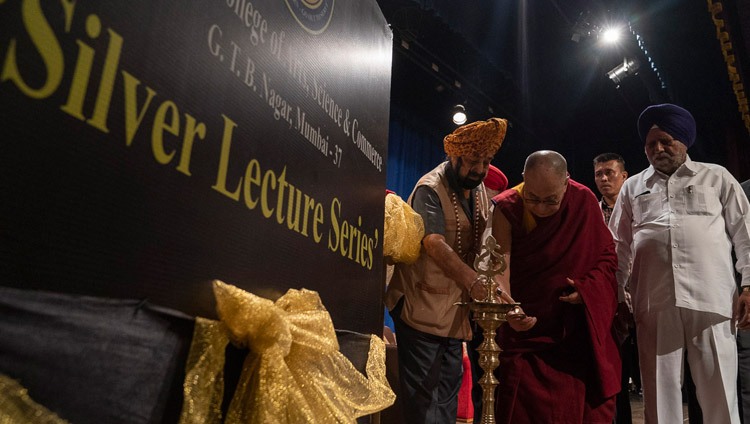 Seine Heiligkeit der Dalai Lama entzündet gemeinsam mit anderen Gästen eine zeremonielle Lampe zu Beginn der 25-jährigen Jubiläumsfeier des Guru Nanak College der Künste, Wissenschaft & Handel. Mumbai, Indien am 13. Dezember 2018. Foto: Lobsang Tsering