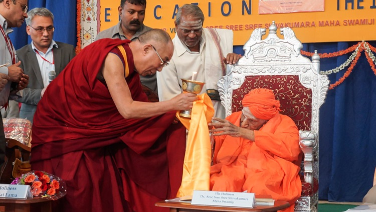 Seine Heiligkeit der Dalai Lama überreicht Sree Shivakumara Swamiji eine Butterlampe während seines Besuchs an der Tumkur Universität in Tumkar, Karnataka, Indien am 27. November 2012. Foto: Jeremy Russell