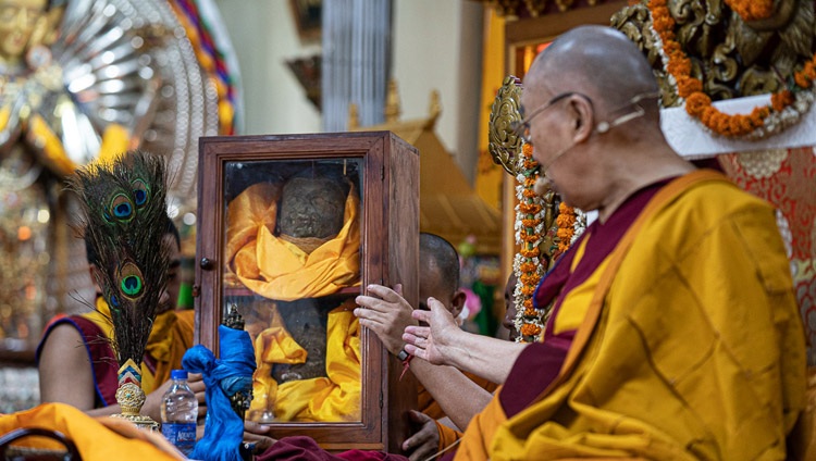 Seine Heiligkeit der Dalai Lama zeigt auf eine Glasbox mit den Überresten der Avalokiteshvara-Statue aus Tibet, die während der Kulturrevolution zerstört wurde. In Dharamsala, HP, Indien am 5. Juni 2019. Foto: Tenzin Choejor