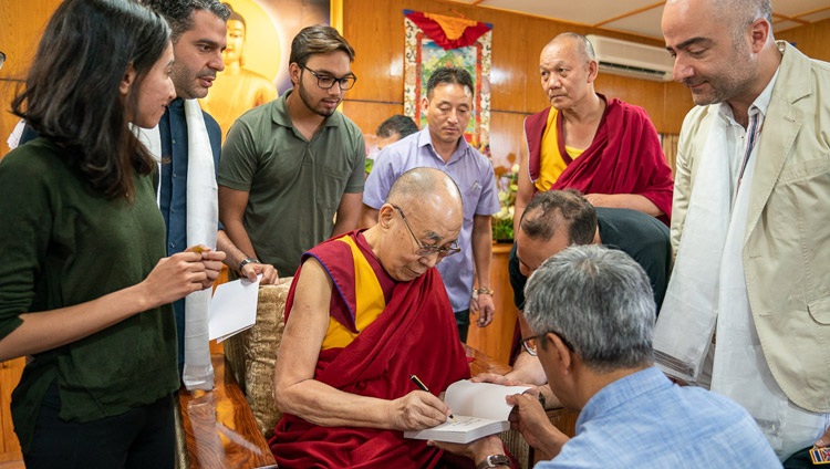 Seine Heiligkeit der Dalai Lama signiert Bücher für die Besucherinnen und Besucher aus dem Iran in Dharamsala, HP, Indien am 7. Juni 2019. Foto: Tenzin Choejor