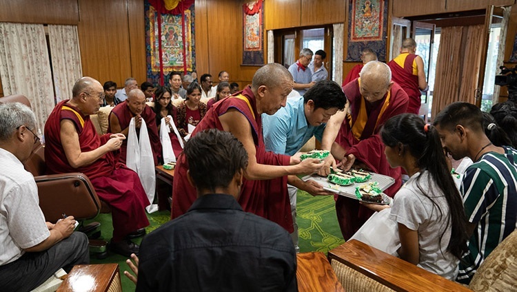 Seine Heiligkeit der Dalai Lama offeriert den Gästen von seinem Geburtstagskuchen – in Dharamsala, HP, Indien am 7. Juli 2019. Foto: Tenzin Choejor