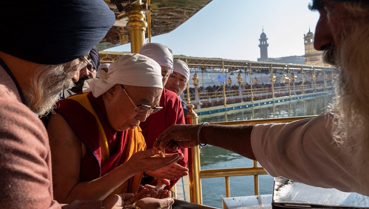 Seine Heiligkeit der Dalai Lama isst Prasad-gesegnetes Essen, das den Pilgern beim Verlassen des Golden Temple angeboten wird. In Amritsar, Punjab, Indien am 9. November 2019. Foto: Tenzin Choejor