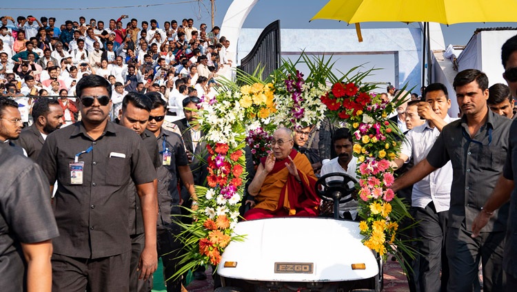 Seine Heiligkeit der Dalai Lama winkt der Menge zu, während er mit einem Elektrobuggy zur Bühne im Sportstadion des P.E.S. College of Physical Education fährt. In Aurangabad, Maharashtra, Indien am 24. November 2019. Foto: Tenzin Choejor