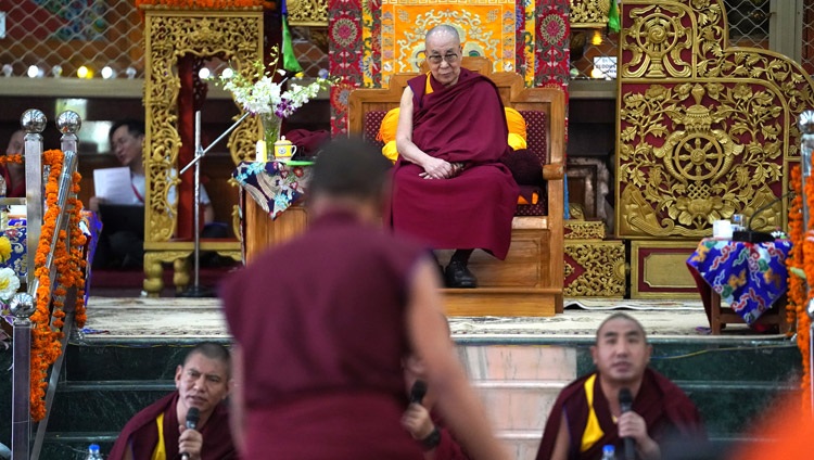 Seine Heiligkeit der Dalai Lama lauscht aufmerksam den Mönchen, welche die buddhistische Philosophie in der Drepung Gomang Assembly Hall debattieren. In Mundgod, Karnataka, Indien, am 15. Dezember 2019. Foto von Lobsang Tsering