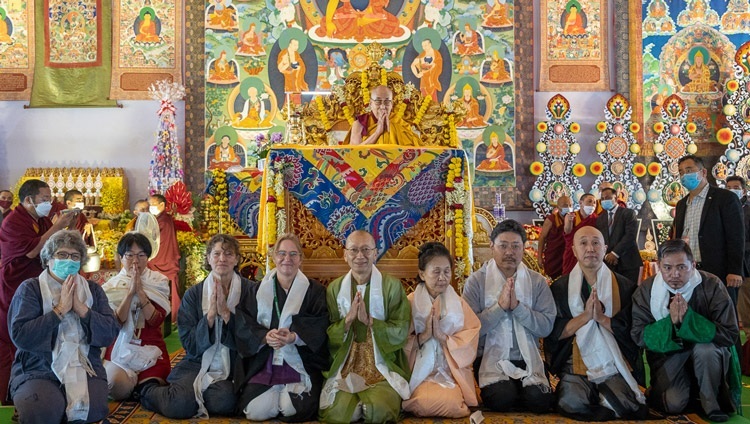 Vertreter des Projekts "Flamme der Hoffnung" posieren für ein Foto mit Seiner Heiligkeit dem Dalai Lama, nachdem sie ihm am zweiten Tag der Unterweisungen in Bodhgaya, Bihar, Indien, am 30. Dezember 2022 eine Laterne überreicht haben, die an der Friedensflamme von Hiroshima entzündet worden war. Foto: Tenzin Choejor