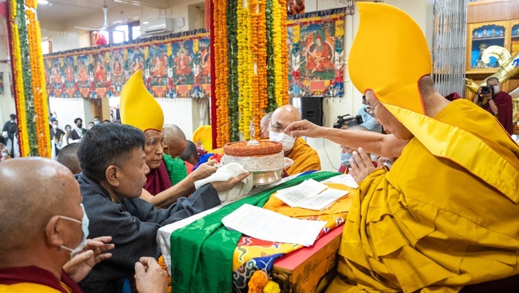 Gaden Tri Rinpoche überreicht Seiner Heiligkeit dem Dalai Lama traditionelle Opfergaben während des Langlebensgebets, das von der CTA am 15. März 2023 im tibetischen Haupttempel in Dharamsala, HP, Indien, angeboten wird. Foto von Tenzin Choejor