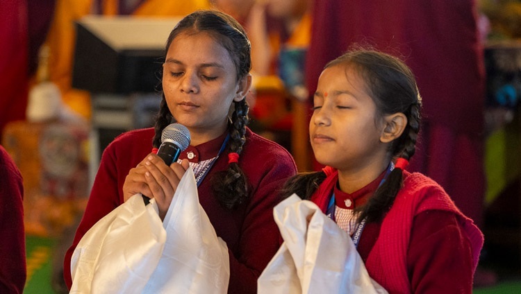 Indische Mädchen, Schülerinnen der Root Institute School in Bodhgaya, singen das "Herz-Sutra" in Sanskrit zu Beginn des zweiten Tages der Unterweisungen Seiner Heiligkeit des Dalai Lama auf dem Kalachakra-Gelände in Bodhgaya, Bihar, Indien, am 30. Dezember 2023. Foto: Tenzin Choejor