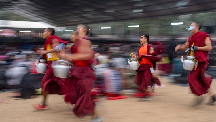 Freiwillige Mönche rennen um die Wette, um den über 50.000 Besuchern des zweiten Tages der Unterweisungen Seiner Heiligkeit des Dalai Lama auf dem Kalachakra Ground in Bodhgaya, Bihar, Indien, am 30. Dezember 2023 Tee zu servieren. Foto: Tenzin Choejor