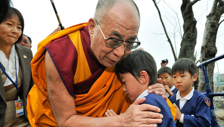 S.H. der Dalai Lama tröstet einen jungen Überlebenden der Tsunami-Katastrophe in der Region Sendai in Japan am 5. November 2011. (Foto: Tenzin Choejor/OHHDL)