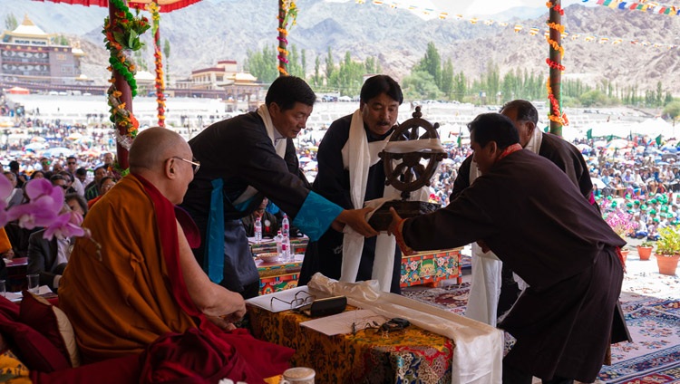 Ein goldenes und silbernes Dharma-Rad als Zeichen der Dankbarkeit werden Seiner Heiligkeit dem Dalai Lama zum 83. Geburtstag überreicht – in Leh, Ladakh, J&K, Indien am 6. Juli 2018. Foto: Tenzin Choejor