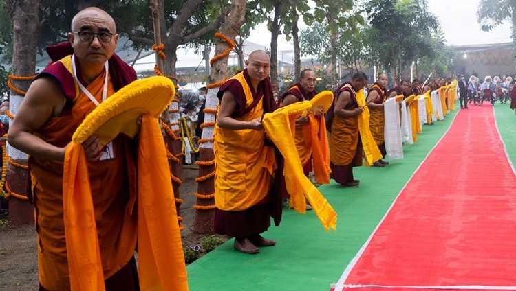 Mönche säumen die Einfahrt zum Kalachakra-Gelände und warten auf die Ankunft Seiner Heiligkeit des Dalai Lama, der am 1. Januar 2024 an einer Langlebenszeremonie in Bodhgaya, Bihar, Indien, teilnehmen wird. Foto von Tenzin Choejor