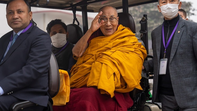 Seine Heiligkeit der Dalai Lama winkt der Menge zu, als er nach Abschluss der Langlebenszeremonie auf dem Kalachakra-Gelände in Bodhgaya, Bihar, Indien, am 1. Januar 2024 mit einem Golfwagen zum tibetischen Kloster zurückfährt. Foto: Tenzin Choejor