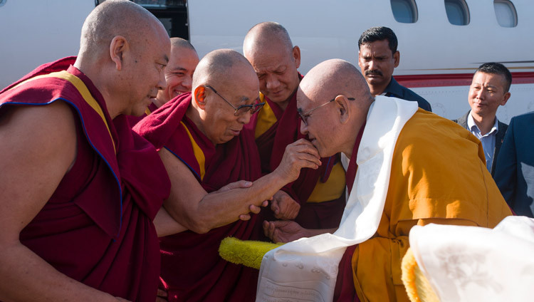 Geshé Jigmé Gyatso, der Abt des Klosters Drepung Gomang, begrüßt Seine Heiligkeit den Dalai Lama bei seiner Ankunft am Flughafen in Hubli, Karnataka, Indien, 12. Dezember 2025. Foto: Tenzin Choejor
