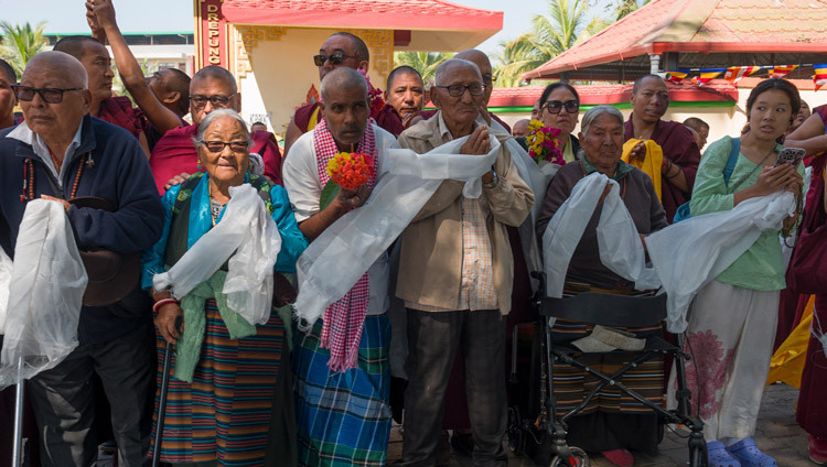 Mitglieder der örtlichen Gemeinschaft säumen die Straßen, um Seine Heiligkeit den Dalai Lama willkommen zu heißen, während seine Fahrzeugkolonne zum Kloster Drepung Gomang in Mundgod fährt. Karnataka, Indien, 12. Dezember 2025. Foto: Tenzin Choejor