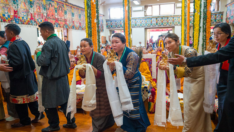 Mitglieder des Organisationskomitees ziehen mit Opfergaben an Seine Heiligkeit den Dalai Lama vorbei während des Langlebensgebets im tibetischen Haupttempel. Dharamsala, HP, Indien, 22. April 2026. Foto: Tenzin Choejor